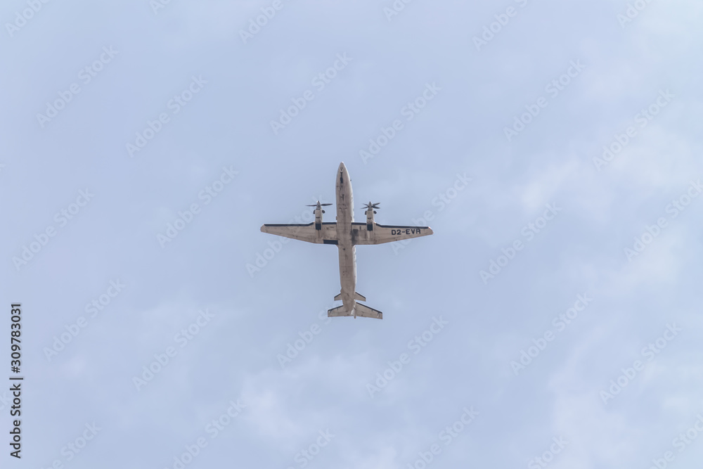 Underside view of a commercial airliner flying, blue sky as background Underside view of a commercial airliner flying, blue sky as background