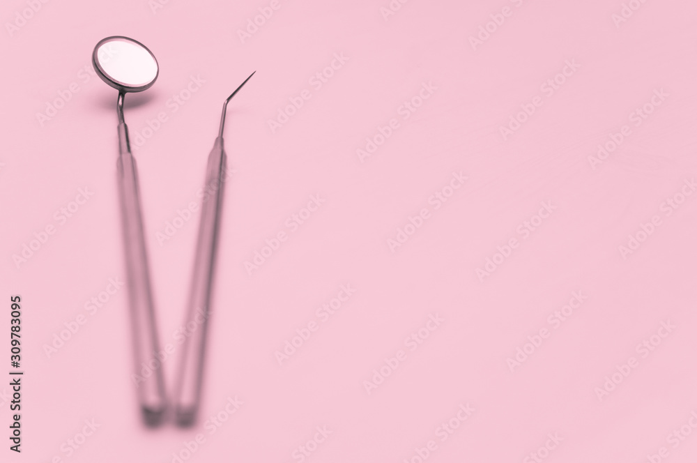 The main professional tools of the dentist are a mirror and a probe. Toned photo, shallow depth of field, soft focus. The main professional tools of the dentist are a mirror and a probe. Toned photo, shallow depth of field, soft focus.