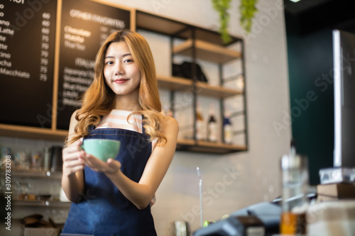 Portrait young Asian woman barista feeling happy smiling at urban cafe. Small business owner Korean girl in apron relax toothy smile