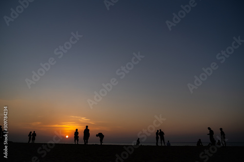 People standing while watching sunset on the beach of Nai Yang in Phuket  Thailand 