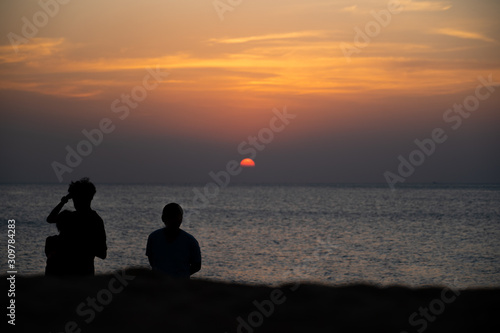 People standing while watching sunset on the beach of Nai Yang in Phuket (Thailand) © Daniel