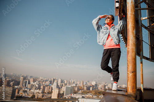 Smiling pretty Asian girl looking into the distance on the roof © Yakobchuk Olena