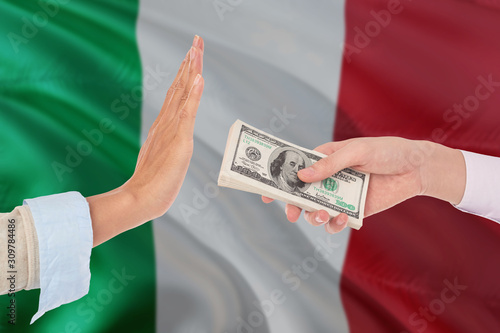 Italy bribery refusing. Closeup of female hands extending a pile of dollar bills to the male hands gesturing as if rejecting the money.