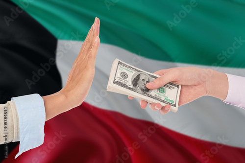 Kuwait bribery refusing. Closeup of female hands extending a pile of dollar bills to the male hands gesturing as if rejecting the money.