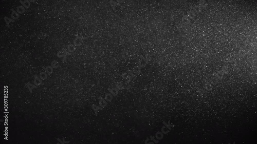 Natural Organic Dust Particles Floating On Black Background. Glittering Sparkling Particles Randomly Spin In The Air With Bokeh. Dynamic Particles With Fast And Slow Motion. Shimmering Dust In Space.