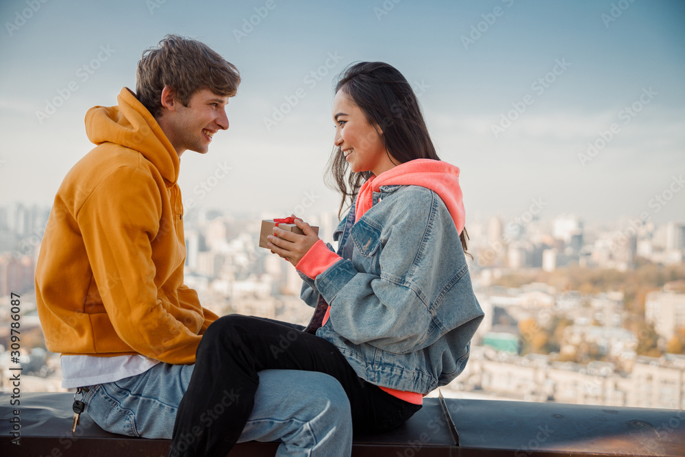 Happy pretty Asian girl holding gift from boyfriend on roof