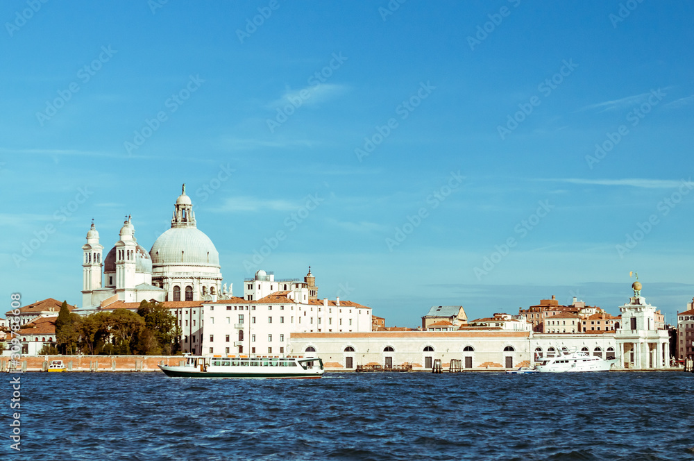Venice promenade with Church of Santa Maria della Salute in summer sunny day with a gondola sights of Italy in the Adriatic