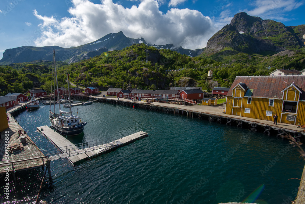 View of the Norwegian Lofoten mountains with the sea in the foreground by boats