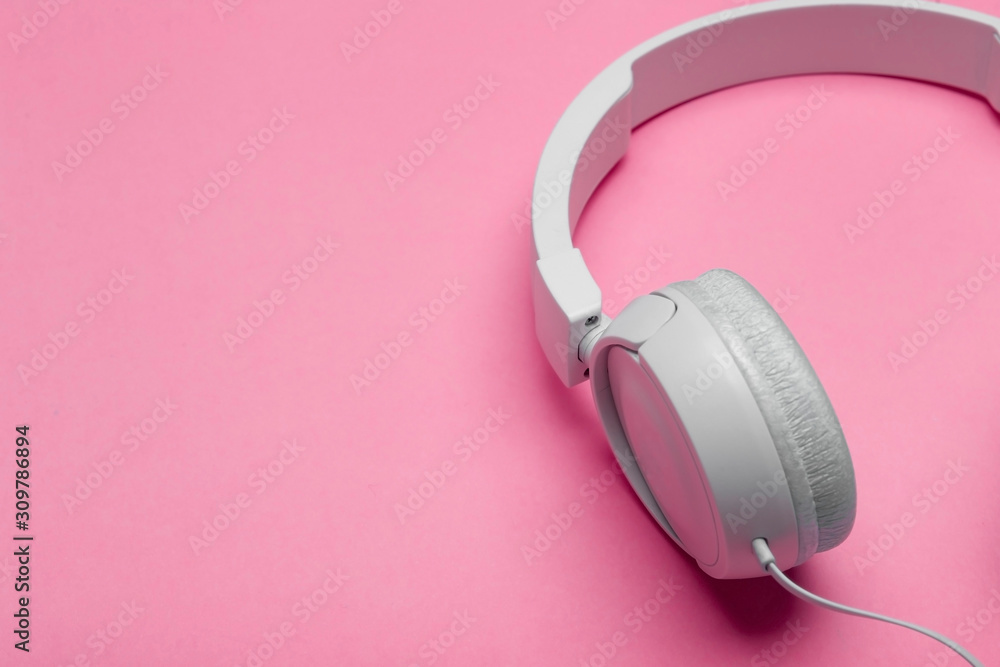 Musical headphones on a colored pink background. Aesthetics retro 80s and minimal concept Musical headphones on a colored pink background. Aesthetics retro 80s and minimal concept
