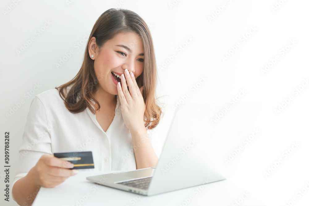 Asian woman using credit card shopping online with laptop computer on white background Asian woman using credit card shopping online with laptop computer on white background