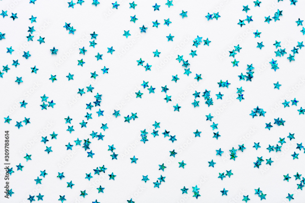 Iridescent Blue color stars. Glitter confetti on white festive background. Holiday Sparkles. Flat lay.