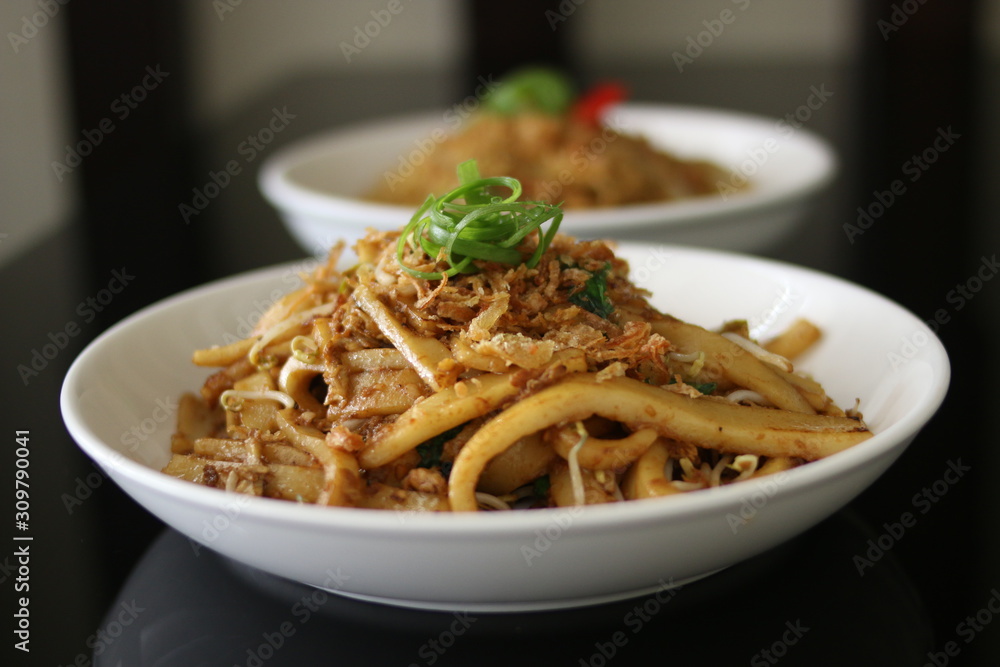 Kwetiau goreng or Fried rice noodles are Indonesian Chinese dishes with front view. Asian Menu Noodles