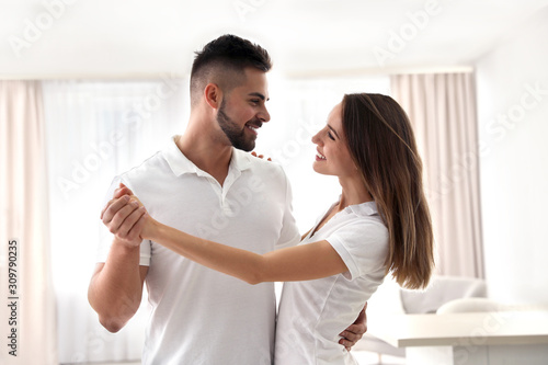 Lovely young couple dancing together at home © New Africa