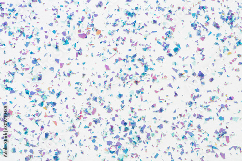 Glowing mica glitter confetti on white background. Festive abstract backdrop. Holiday Flat lay.