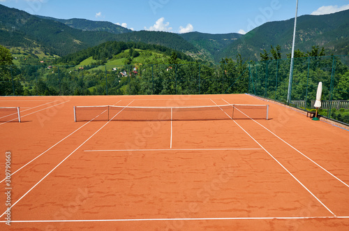 Empty outdoor tennis court in a picturesque landscape on a sunny day © branislav