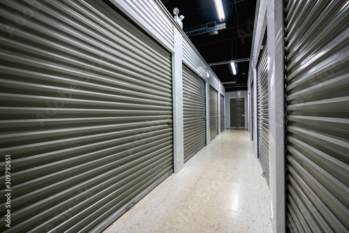 Fotografi Long storage facility corrodor. Garage doors with light