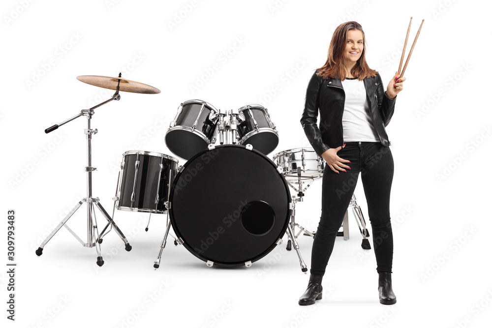 Fototapeta premium Young female posing with a drum set and holding drumsticks