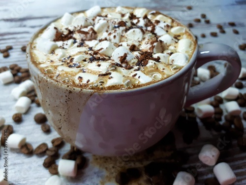  close-up of a hot drink, a cup of coffee / cocoa with marshmallows and chocolate chips on an abstract wooden surface background