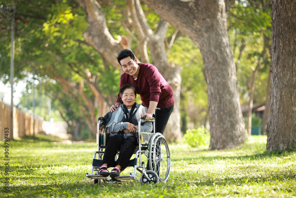 Asian senior woman on wheelchair with son Asian senior woman on wheelchair with son