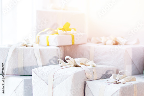 White christmas presents gift with silver ribbon bow, sunlight