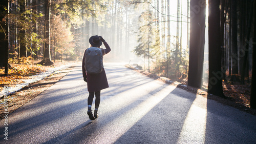 Woman Walks In Autumn Forest with large backpack