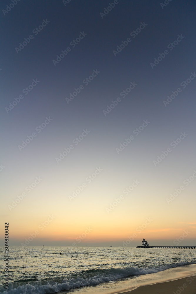 Fototapeta premium The beautiful light of the sunset at the sea. Mae Ramphueng Beach, Taphong Subdistrict, Mueang Rayong District, Rayong Province, Thailand