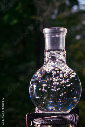 Glass flask with boiling water on a gas burner.
