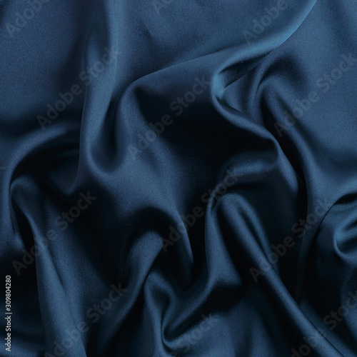 Wavy blue silk, atlas or veil fabric, crumpled with creases, bended in spiral wrinkle