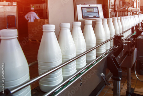 Obraz na płótnie White plastic milk bottles on the conveyor on a modern dairy plant w salonie