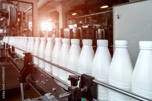 Obraz na płótnie White plastic milk bottles on the conveyor on a modern dairy plant w salonie