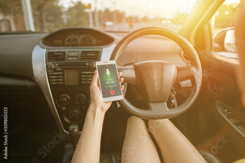 Close-up of woman voice messaging behind the wheele concept photo