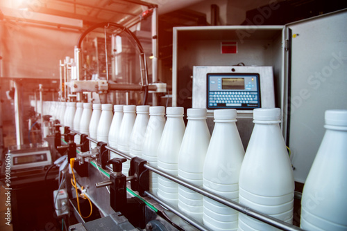 Obraz na płótnie White plastic milk bottles on the conveyor on a modern dairy plant w salonie