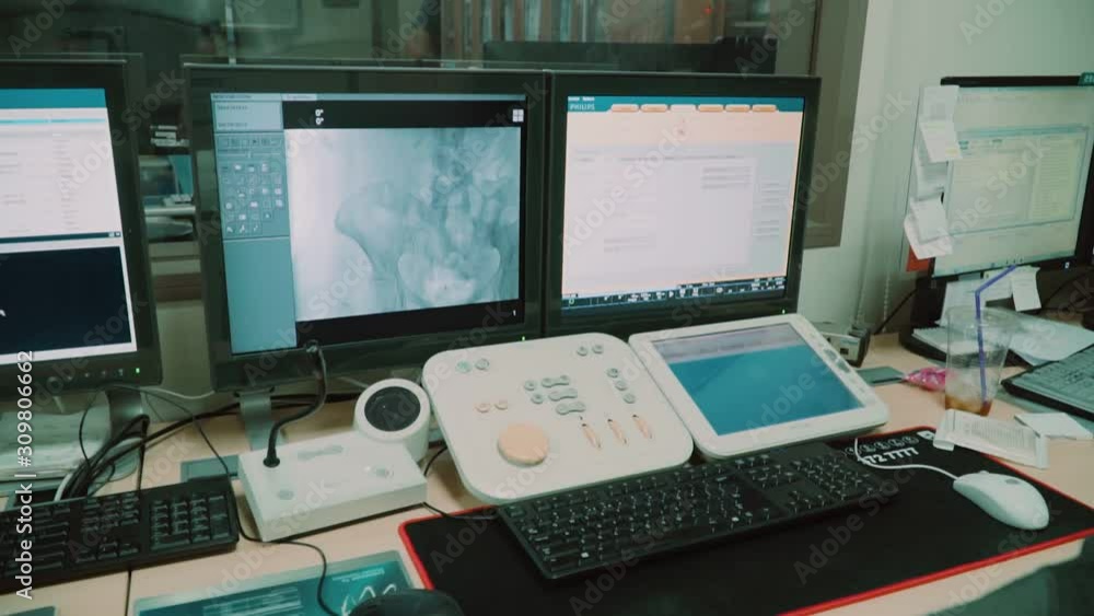Modern medical pre-operation room in which doctors look into monitors with biometric data Modern medical pre-operation room in which doctors look into monitors with biometric data