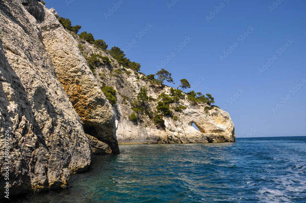Mediterranean sea coast landscape, blue clear sky and sea, with an opening in the rock.