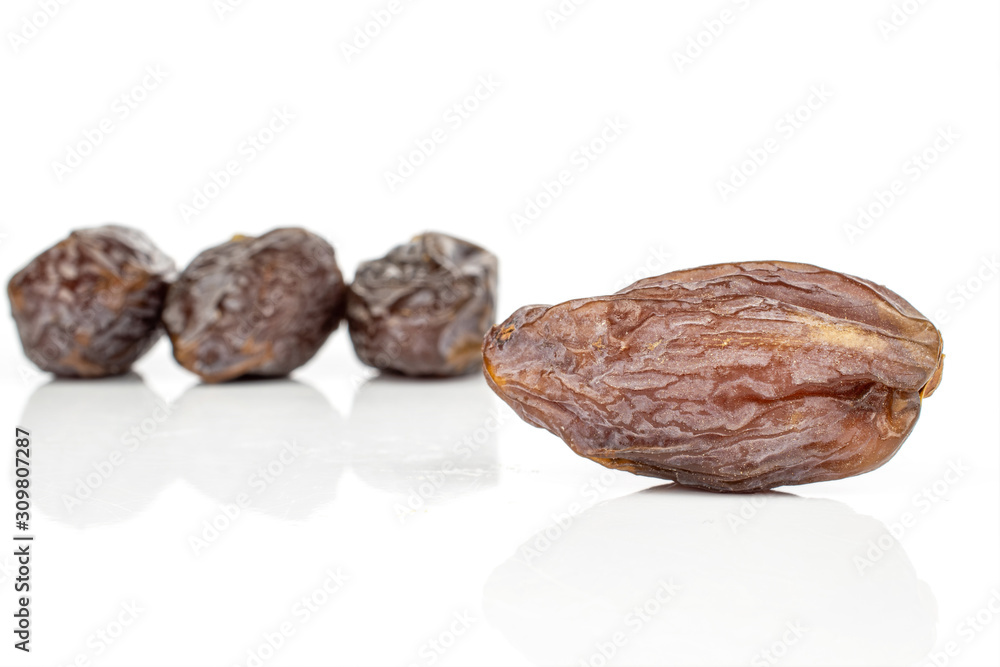 Group of four whole dried brown date fruit isolated on white background Group of four whole dried brown date fruit isolated on white background