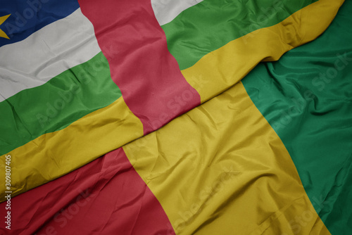 waving colorful flag of guinea and national flag of central african republic.