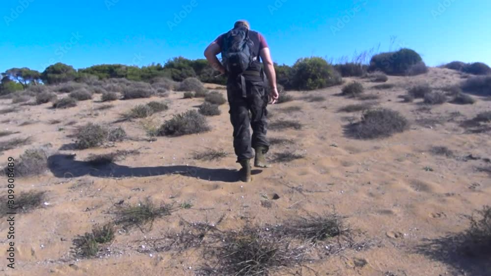 Lonely tired tourist man walk by desert. Lonely tired tourist man walk by desert.