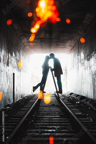 Couple kissing over ladder on railtracks
