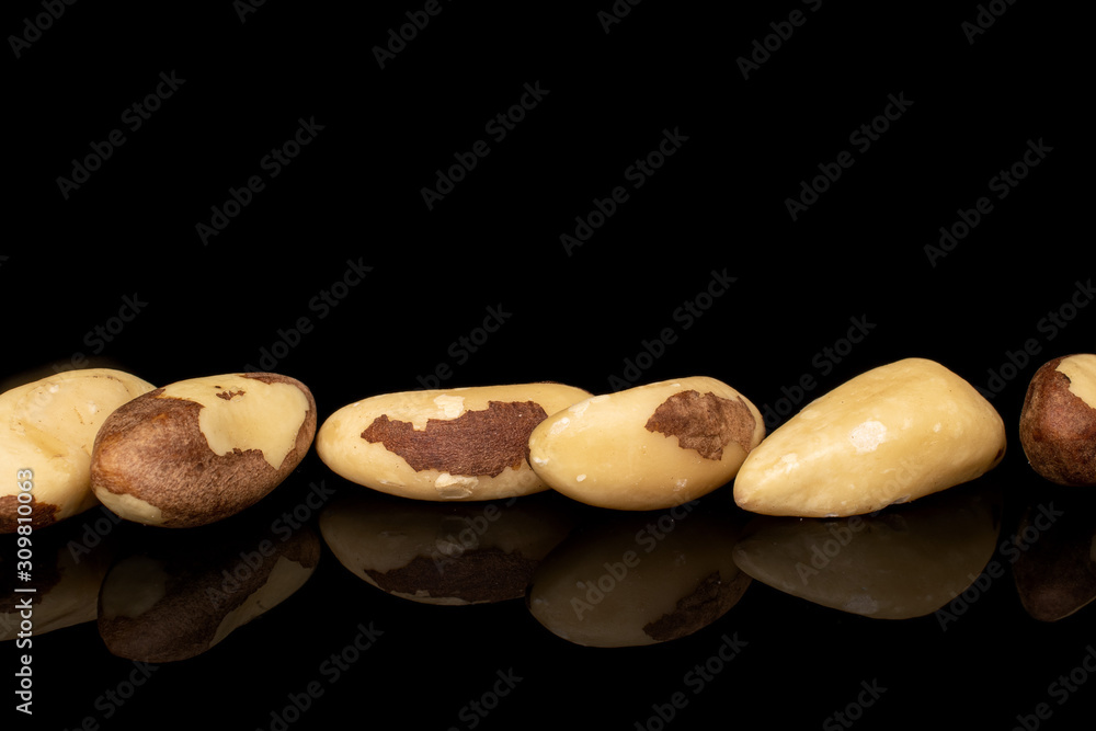 Lot of whole brazil brown nut line isolated on black glass Lot of whole brazil brown nut line isolated on black glass