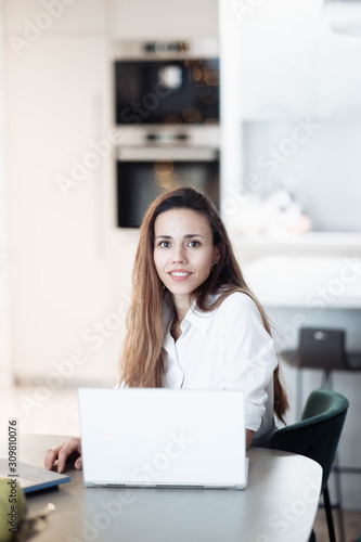 Woman business worker in modern bright coworking office working with laptop, interior designer.