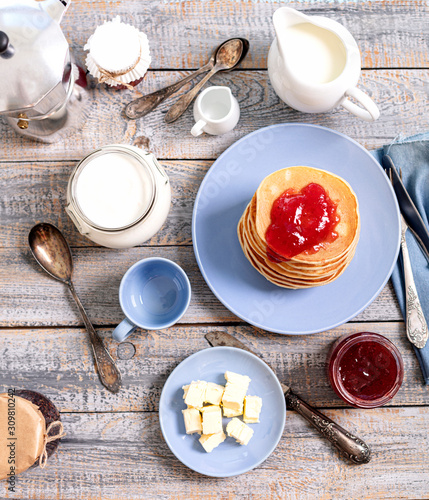 Tasty breakfast. Pancakes with strawberry confiture and butter.