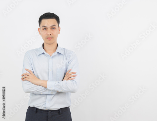 Young handsome asian business man looking to camera with arms crossed isolated on white background.