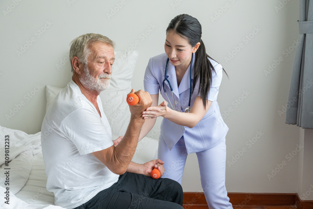 Obraz premium Young nurse take care senior man at home, Sernior man in lifting dumbell with nurse, Health care concept