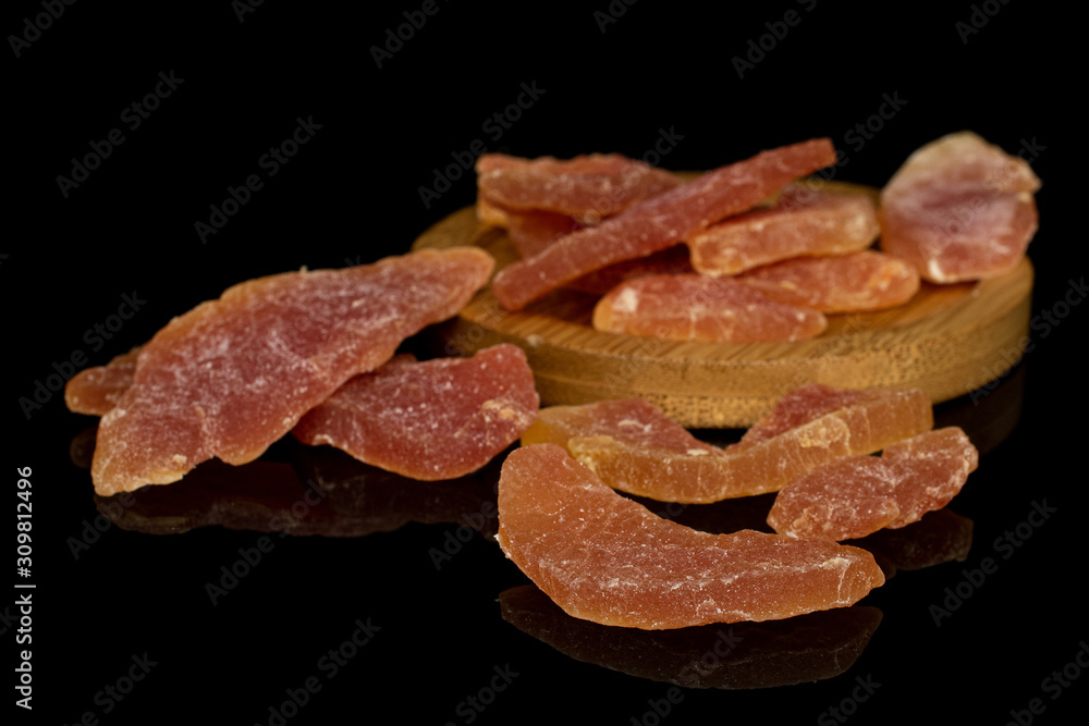 Lot of whole dried orange papaya piece on round bamboo coaster isolated on black glass Lot of whole dried orange papaya piece on round bamboo coaster isolated on black glass