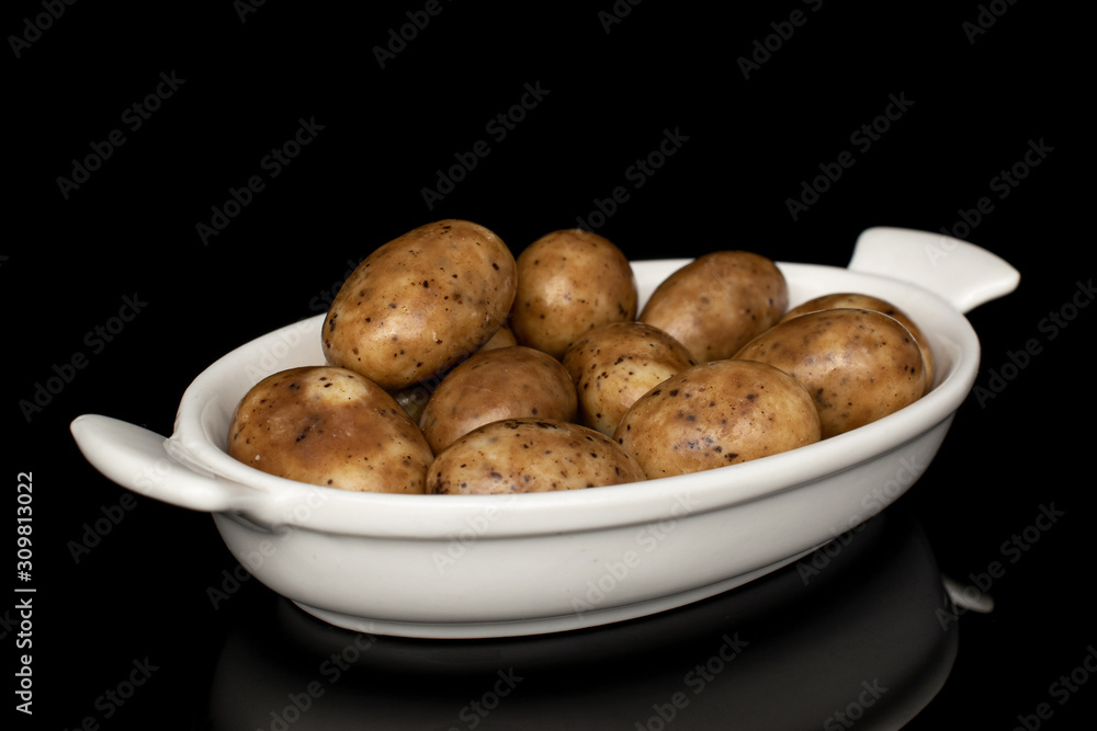 Lot of whole tiramisu brown almond nut on white ceramic plate isolated on black glass Lot of whole tiramisu brown almond nut on white ceramic plate isolated on black glass