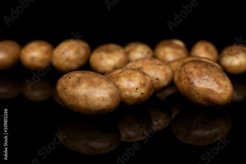 Lot of whole arranged tiramisu brown almond nut isolated on black glass