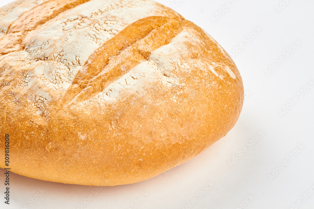 Fresh homemade bread on white background. Round loaf of bread close up. Crusty bread recipe.