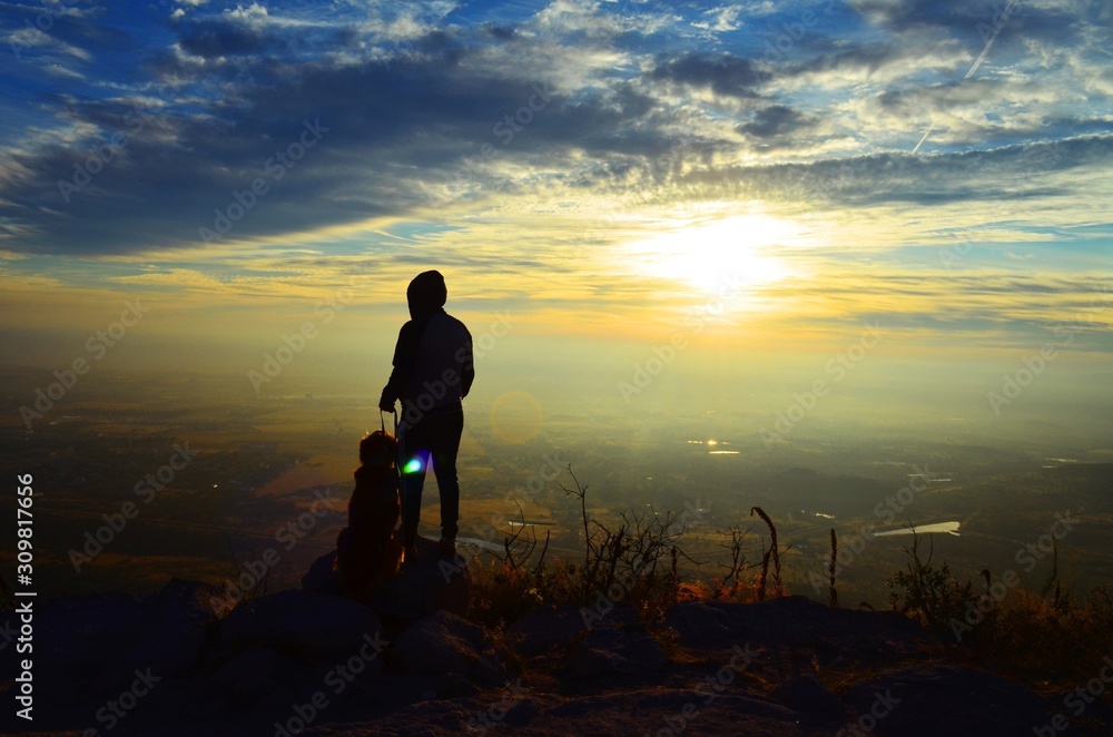 Hombre con su perro arriba de una montaña 