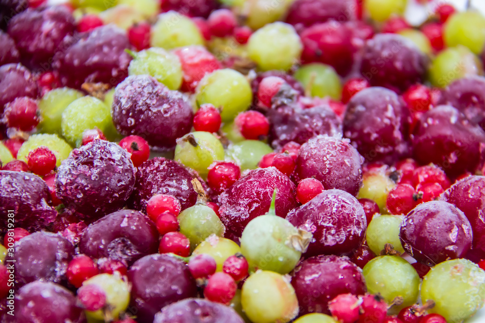 Frozen berries from the freezer. Background with frozen cherries, currants and gooseberries. Healthy berry mix. Frozen berries from the freezer. Background with frozen cherries, currants and gooseberries. Healthy berry mix.