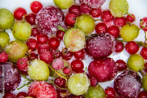 Frozen berries from the freezer. Background with frozen cherries  currants and gooseberries. Healthy berry mix.